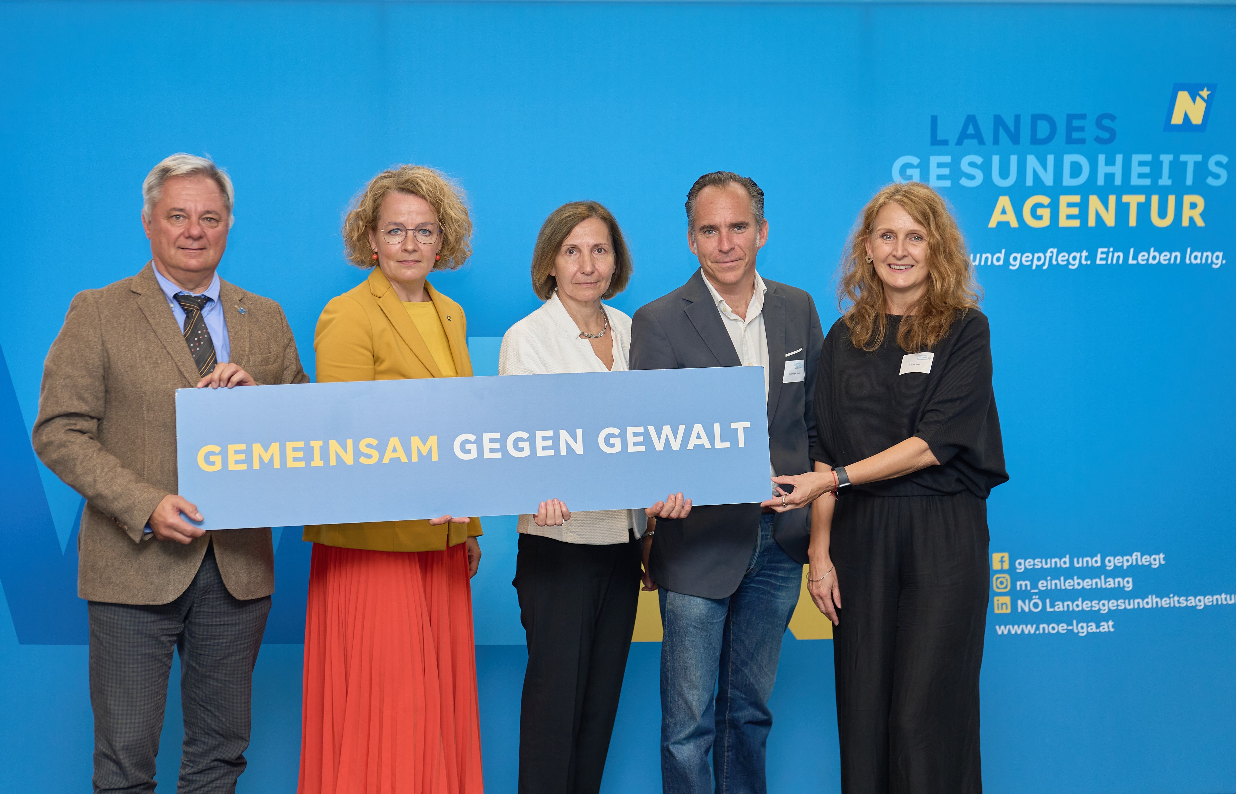 TeilnehmerInnen der Opferschutzkonferenz mit Schild "Gemeinsam gegen Gewalt"